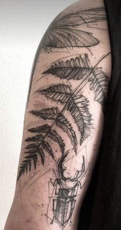 a man's arm with a fern tattoo on it