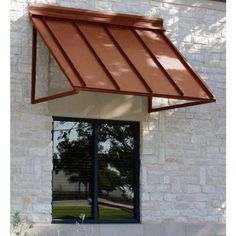 an awning on the side of a white brick building