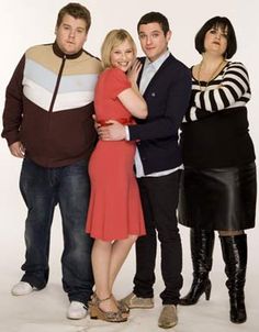 four people are posing for a photo in front of a white background and one person is hugging the other