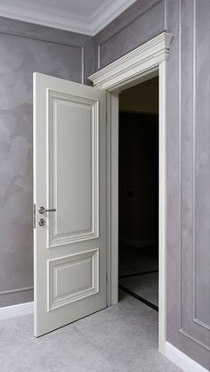 an open door leading into a room with gray walls and white trim on the doors