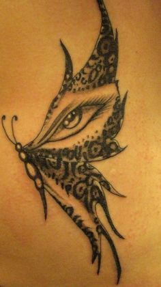 the back of a woman's stomach with an artistic tattoo design on her left side