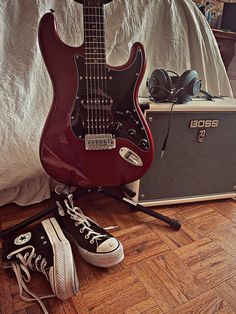 an electric guitar and some shoes on the floor