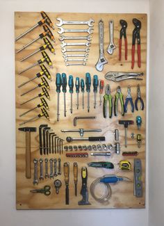 a wooden board with tools on it and some screwdrivers hanging from the wall