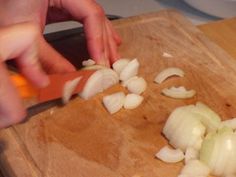 someone chopping onions on a cutting board with a knife