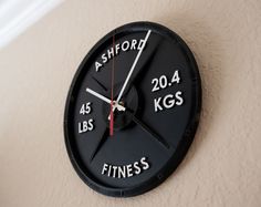 a black clock with the words ashford and fitness written on it's face