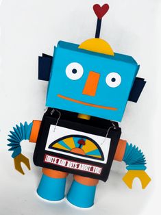 a blue and orange robot made out of paper with hearts on it's head