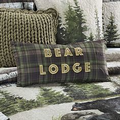 the bear lodge bedding is made up with plaid and pine trees, which are accented with gold lettering