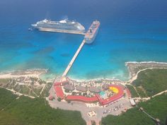 an aerial view of a beach and ocean with a plane in the sky above it