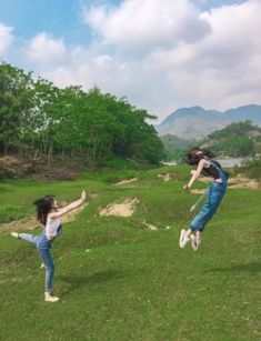 two people are jumping in the air on some grass