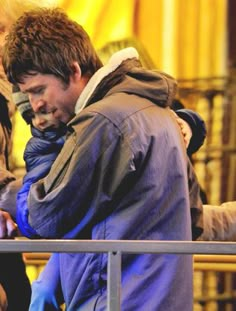 a man is looking at his cell phone while standing in front of some other people