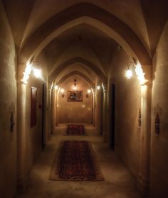 a long hallway with lights on either side and a rug on the floor in between