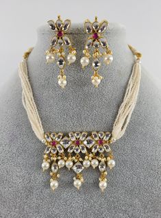 Featuring a stunning pachi kundan necklace with red middle stone and pearl drops. Real looking! Finest quality kundan used! Necklace is adjustable with a Dori/Cord. Set includes necklace and matching earrings Highest quality and craftsmanship. Please let me know if you have any questions     ~Dimensions-   Brooch Length: 4.7 cm, Brooch Width: 5.5 cm approx., Necklace Round: 22 cm approx. + tie.                            Each Earring: Earring Length: 4.5 cm approx., Earring Width: 2.3 cm approx. Jewelry Kundan, Kundan Necklace Set, Kundan Jewelry, Cord Set, Kundan Necklace, Statement Choker, Kundan Necklaces