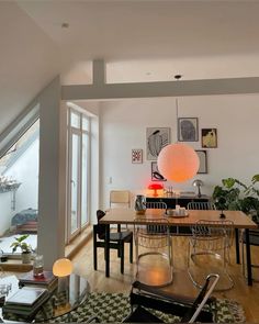 a living room filled with lots of furniture and a large light hanging over the table