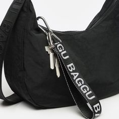 Decorate your bag and keep your keys easy to find with Baggu's Logo Keychain in the shade Black + White. Perfect for a stocking stuffer or small gift idea, this is a must-have accessory for your bags!