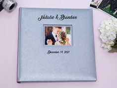 a wedding album with an image of a bride and groom on it next to flowers