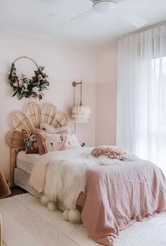 a pink bedroom with wicker headboard and white bed linens on the floor