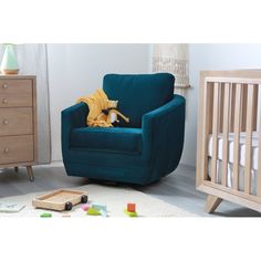 a baby's room with a blue chair and crib