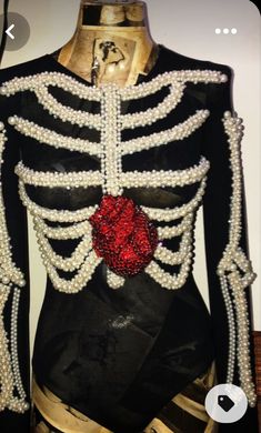 a mannequin dressed in black and gold with pearls on it's chest