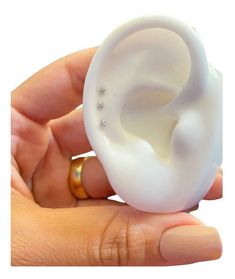 a person is holding an ear shaped ring