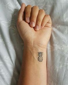 a small pineapple tattoo on the wrist