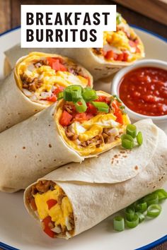 breakfast burritos on a plate with salsa and green onions