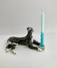 a dog figurine laying next to a lit candle