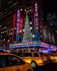 the radio city christmas tree is lit up at night