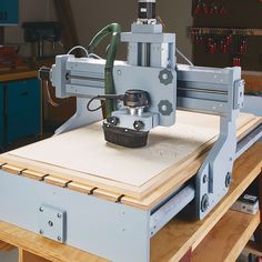 a machine that is sitting on top of a wooden table in a room filled with tools