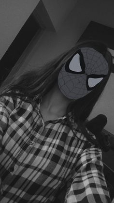 a woman wearing a spiderman mask with long hair