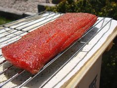 a large piece of meat is cooking on a grill