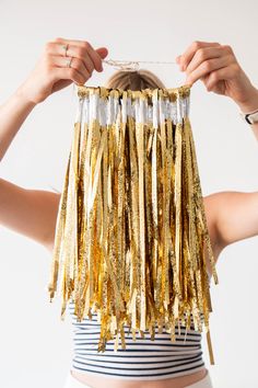 a woman is holding up some gold tinsel