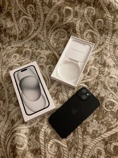 an iphone case sitting on top of a bed next to a box with its lid open