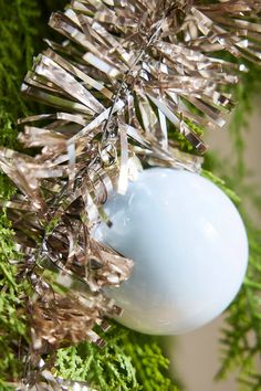 an ornament hanging from a christmas tree with tinsel on it's branches