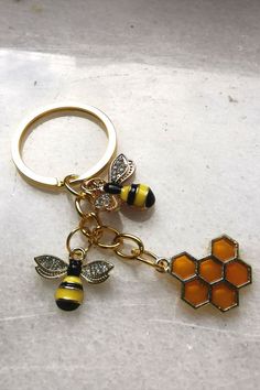 a yellow and black keychain with two bees on it, sitting on a white surface