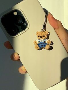 a person holding an iphone case with a teddy bear on it