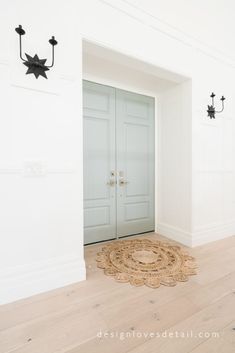 an empty room with two doors and a rug on the floor