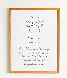 a dog's paw print hanging on the wall next to a wooden frame with writing