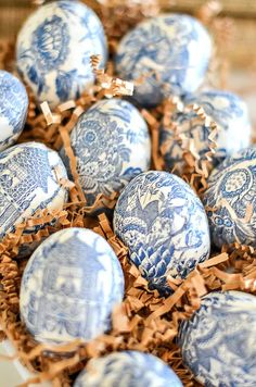 blue and white decorated eggs in a nest