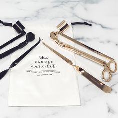 three pairs of gold scissors sitting on top of a white napkin next to black handles