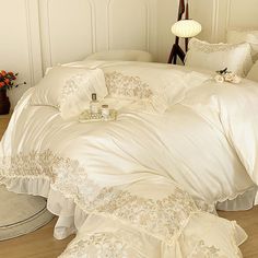 a bed with white comforters and pillows on it