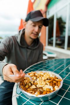 a man sitting at a table with a bowl of food in front of his face