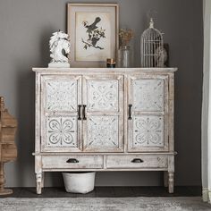 a white cabinet sitting next to a birdcage