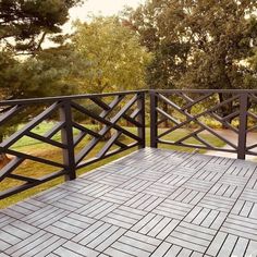 an outdoor deck with black railings and brick tiles