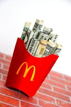 a red bag filled with money sitting on top of a brick wall