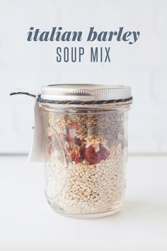 a jar filled with food sitting on top of a table next to a tag that says italian barley soup mix