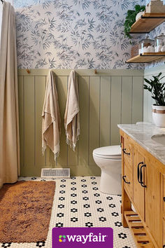 a bathroom with two towels hanging on the wall and a rug in front of it