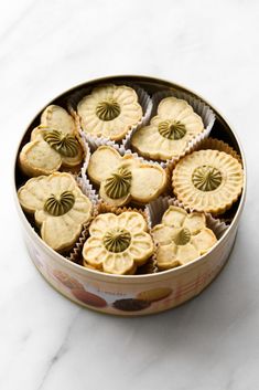 a tin filled with cookies sitting on top of a white counter