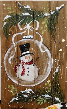 a painting of a snowman in a glass ornament on a wooden board