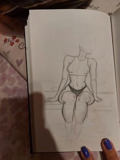 a drawing of a woman's torso and legs sitting on a table next to a book