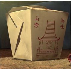 an origami box sitting on the ground with chinese writing written in red ink